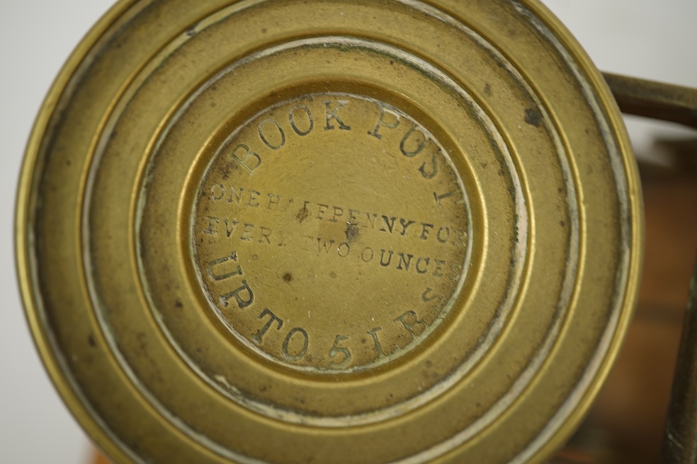 A Sampson Mordan & Co. set of brass postal scales on an oak base with weights, 27cm wide, with engraved prices for Inland Letter Post, etc.
